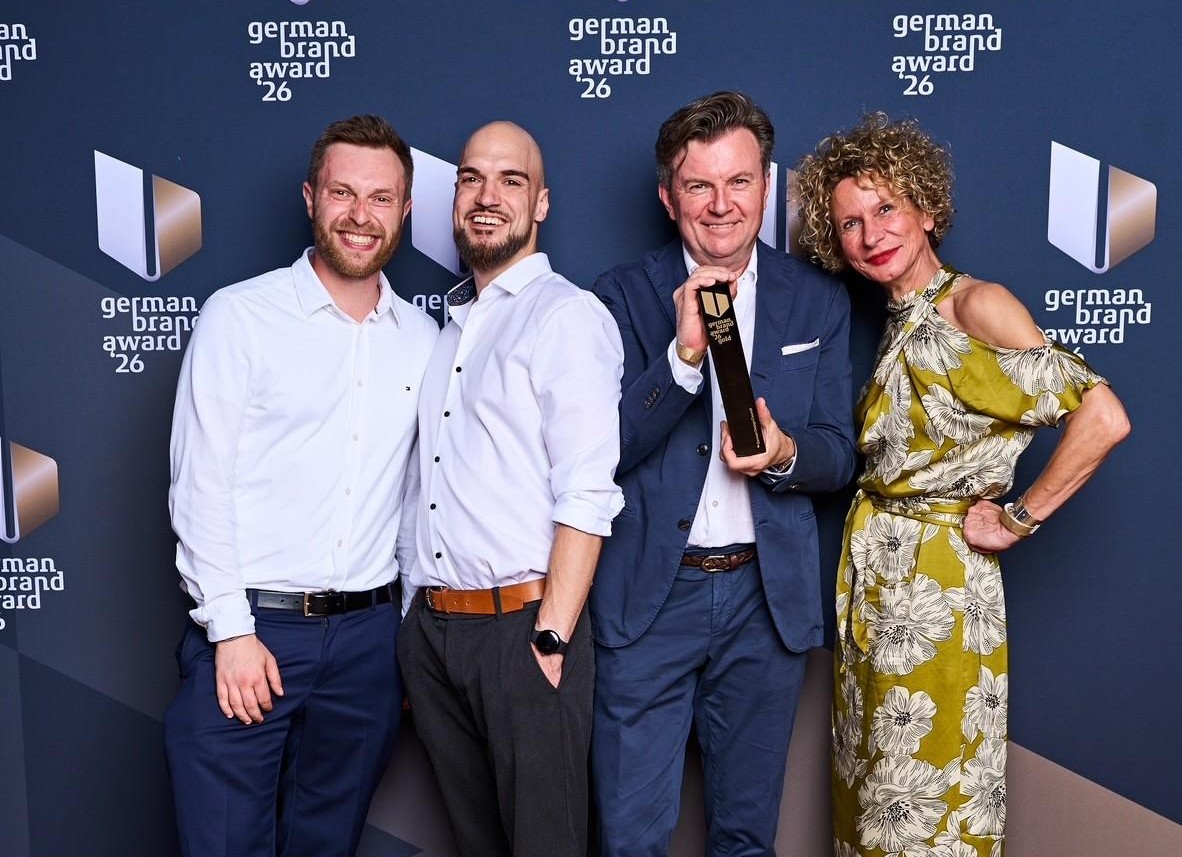 Die Digitalagentur com&on nimmt den German Brand Award 2026 für die DNK-Plattform entgegen.